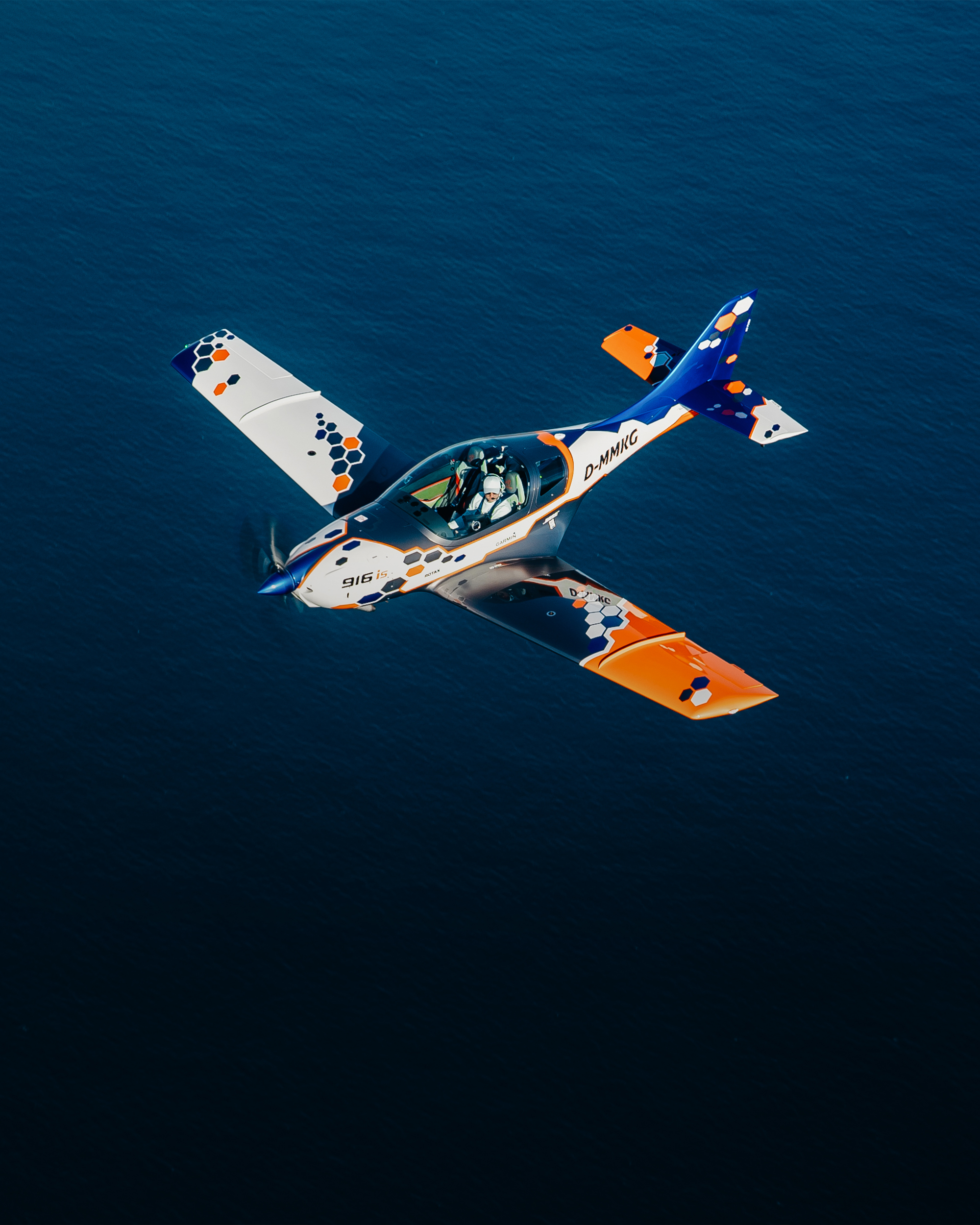 white MOSAIC LSA aircraft flying over ocean